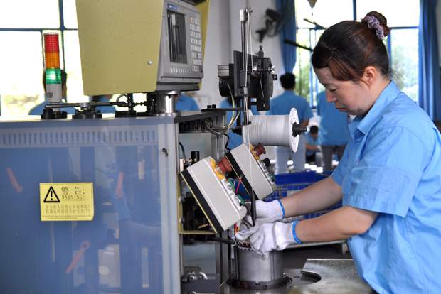 皖南電機員工在操作自動嵌線設備 皖南電機員工在操作自動嵌線設備